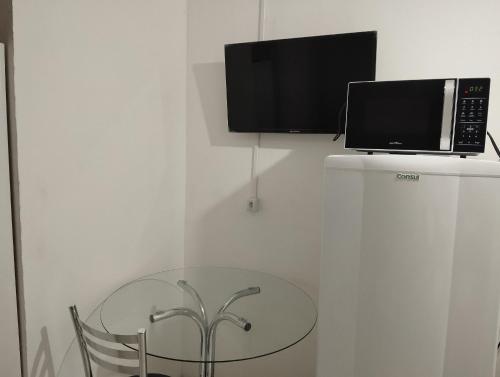 a table with a microwave on top of a refrigerator at Prédio no bairro Rio Branco in Caxias do Sul