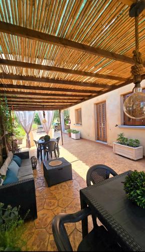 an outdoor patio with a wooden pergola at Affittacamere Il FIORE in Posada