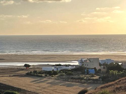 a view of a beach with a building and the ocean at Apartment in a beachfront house in Briyech