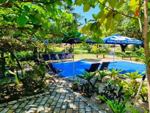 a swimming pool with umbrellas and chairs next to at Viva O Sonho 