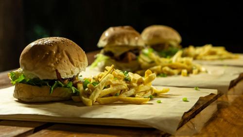 three sandwiches and french fries on a table at Viva O Sonho 