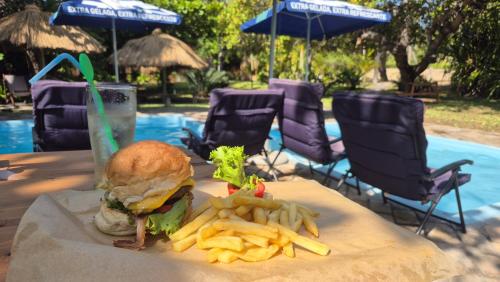 a sandwich and french fries on a table with a drink at Viva O Sonho 
