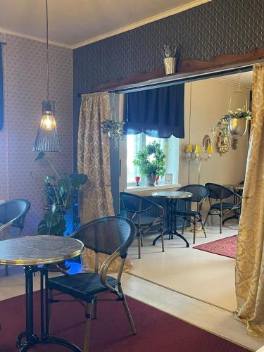 a dining room with tables and chairs and a kitchen at Hotel Merikruunu in Dragsfjärd
