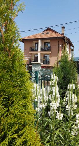 a house with white flowers in front of it at Семеен хотел При Вергил in Sapareva Banya