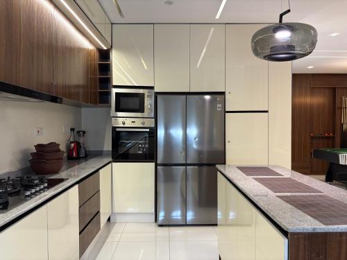 a kitchen with a stainless steel refrigerator and appliances at Cozy, Serene Ambiance With Nice Balcony Views in Ikate