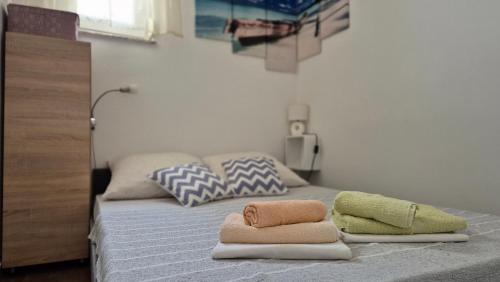 a bedroom with a bed with towels on it at Apartman Bilandžić Drage in Drage