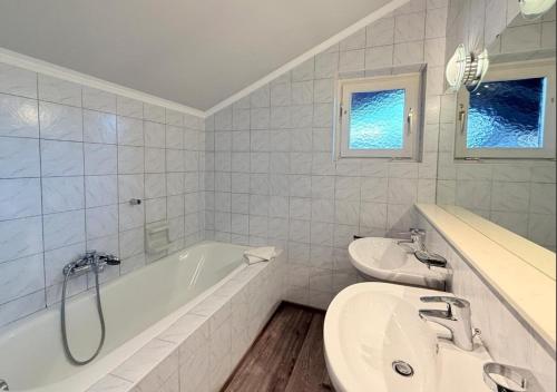 a white bathroom with a tub and a sink at Luxury 4BR Villa Velden Pool Grill in Velden am Wörthersee