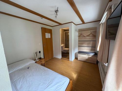 a bedroom with a bed and a bathroom at Garni Sternen in Obstalden