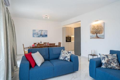 a living room with a blue couch and a dining room at Marios Suite Corfu in Corfu