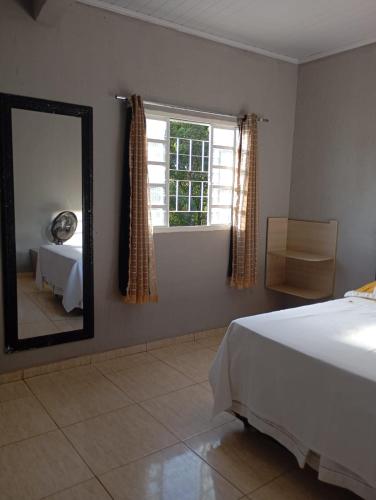 a bedroom with a bed and a mirror and a window at Apto 11 bom preço benefício in Brasília