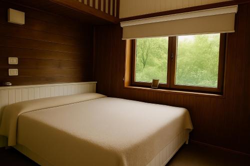 a small bedroom with a bed and a window at La Râu - Căsuța de sus in Cîmpulung