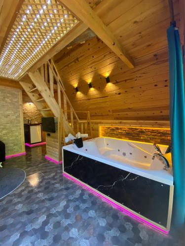a large room with a tub in a wooden ceiling at ELASYA BUNGALOV in Rize