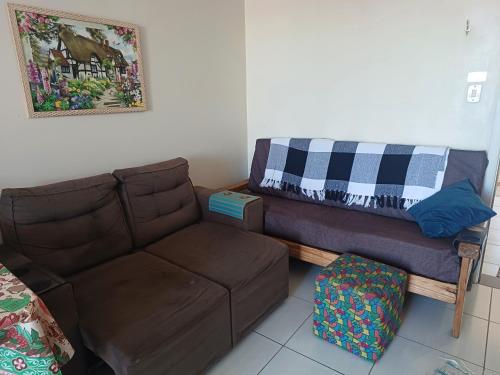 a living room with a couch and a blanket at Apart próximo a Unimed de 2 quartos com Ac e garagem in Santo Ângelo