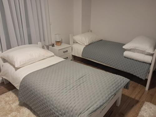 a bedroom with two beds and a nightstand withskirts at Galija in Tomislavgrad