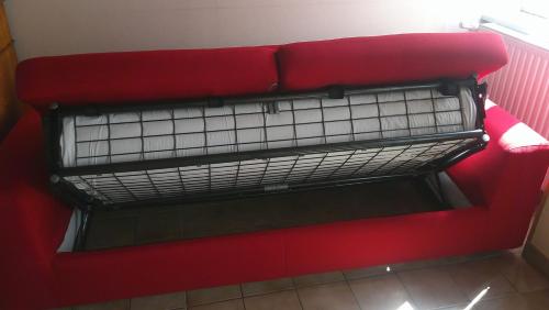 a red couch sitting in a room at Maison entre Cherbourg et Mont Saint Michel in Saint-Aubin-du-Perron
