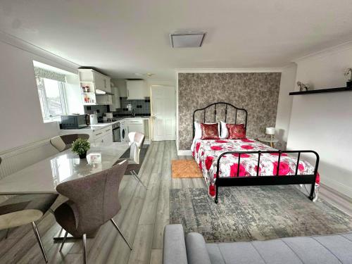 a bedroom with a bed and a table and a kitchen at Studio Paris Double Room in London