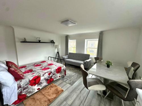 a bedroom with a bed and a living room with a table at Studio Paris Double Room in London