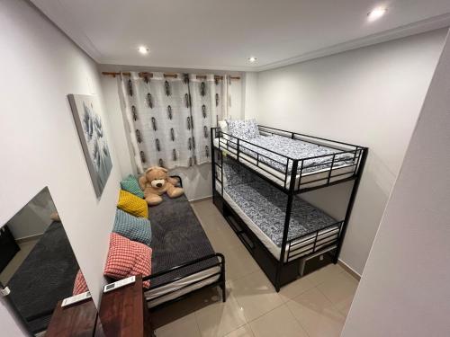 a room with two bunk beds and a teddy bear at Benidorm Ambra in Villajoyosa