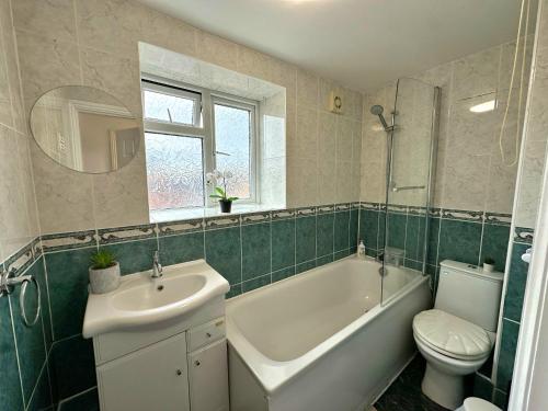 a bathroom with a sink and a tub and a toilet at Studio Paris Double Room in London