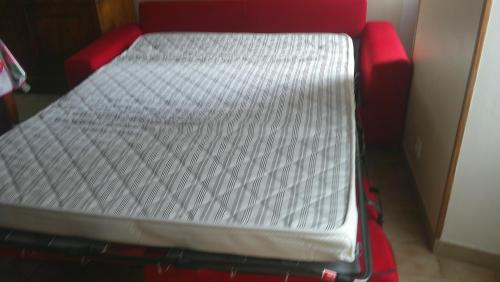 a bed sitting on top of a red suitcase at Maison entre Cherbourg et Mont Saint Michel in Saint-Aubin-du-Perron