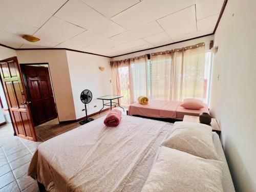 a bedroom with two beds and a window at Casa Las Brisas del Miravalles in Bagaces
