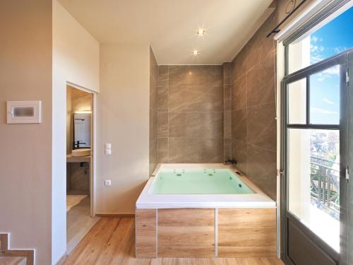 a bathroom with a bath tub in a room at Luxury Studios & Cozy Apartments by White Hills in Arachova