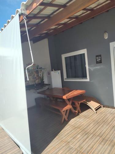 a dining room with a wooden table and a television at Beach House in Camaçari