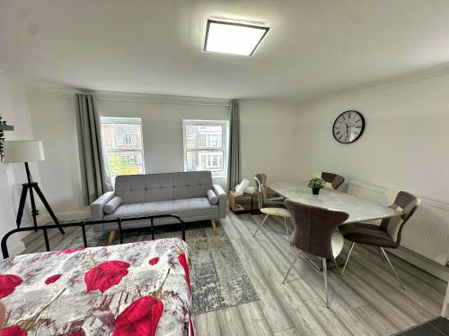 a living room with a bed a table and a couch at Studio Paris Double Room in London