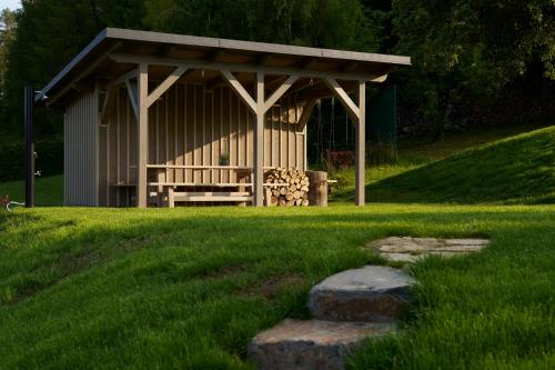 a gazebo with a bench in the grass at Chalupy Raz Dva in Roprachtice