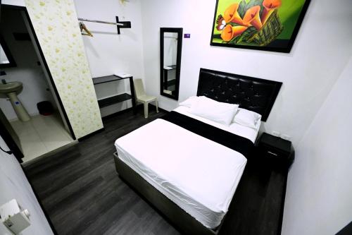 a small bedroom with a bed and a bathroom at Hotel Puerta del Sol de Uraba in Apartadó