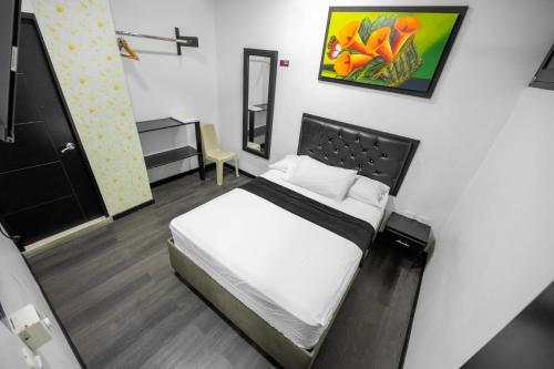 a small bedroom with a bed and a mirror at Hotel Puerta del Sol de Uraba in Apartadó