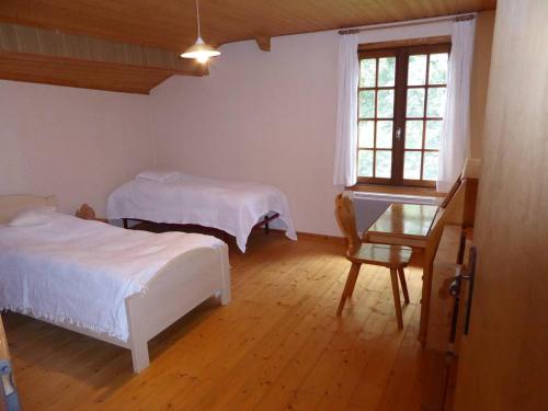 a bedroom with two beds and a chair and a window at Landhaus mit Umschwung in Pont-du-Bois
