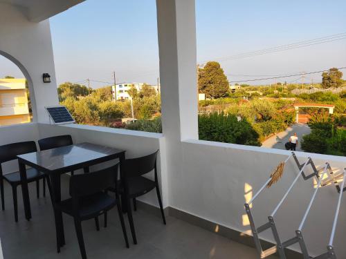 a dining room with a table and chairs and a window at Villa Maroula in Afantou