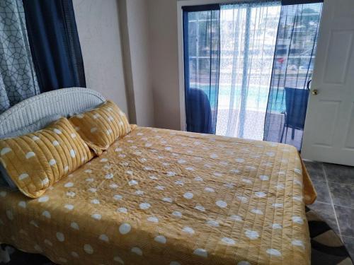 a bedroom with a bed with a yellow comforter at TheTotal Florida life style heated pool 5 bedrooms in Punta Gorda