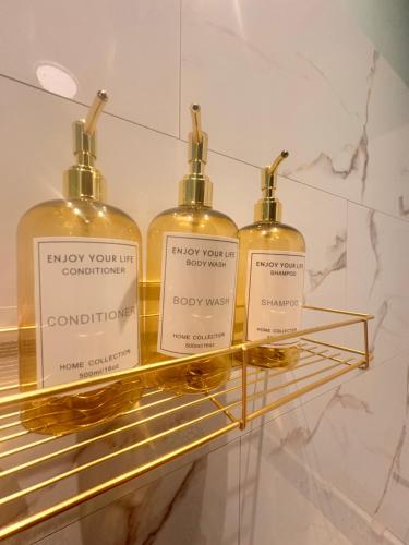 three bottles of whisky sitting on a gold shelf at Secret Rock - Jaccuzi privé in La Roche-en-Ardenne