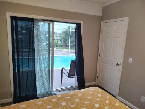 a bedroom with a sliding glass door with a view of a pool at TheTotal Florida life style heated pool 5 bedrooms in Punta Gorda