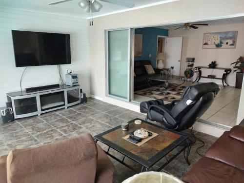 a living room with a flat screen tv on the wall at TheTotal Florida life style heated pool 5 bedrooms in Punta Gorda