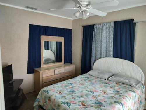 a bedroom with a bed with a dresser and a mirror at TheTotal Florida life style heated pool 5 bedrooms in Punta Gorda