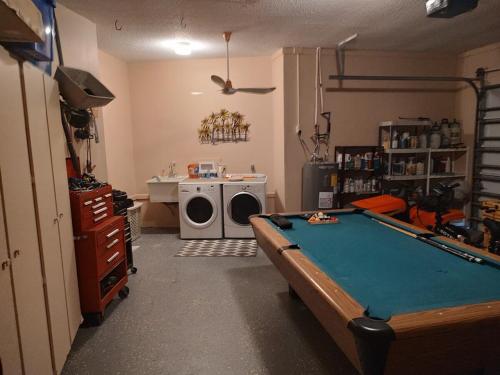 a living room with a pool table and a washing machine at TheTotal Florida life style heated pool 5 bedrooms in Punta Gorda