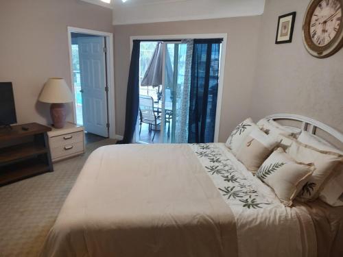 a bedroom with a bed with a clock on the wall at TheTotal Florida life style heated pool 5 bedrooms in Punta Gorda