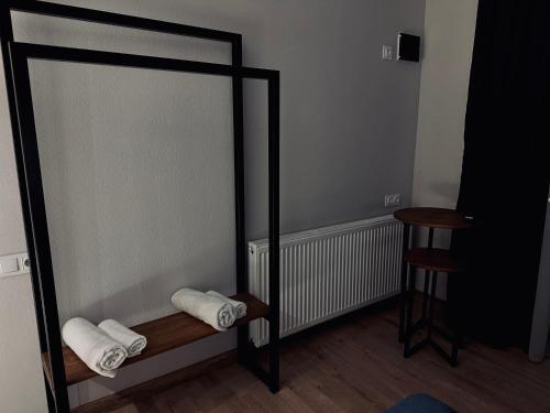 une pièce avec deux serviettes sur une étagère et un tabouret dans l'établissement Hotel Daba Kazbegi, à Kazbegi