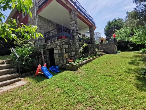 a house with a yard with two childrens toys at Casa Piedra Libre in Manzanares el Real