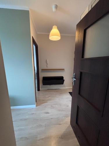 an open door to a room with a bench in the background at Oliwkowy Apartament Hennela in Warsaw