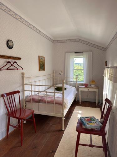 a bedroom with a bed and two chairs and a window at Solberg Inn 