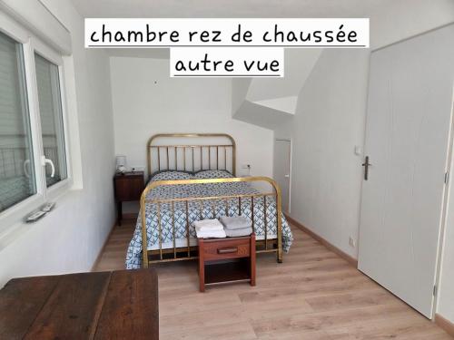 a small bedroom with a bed and a table at Maison de campagne in Saint-Bonnet-Tronçais