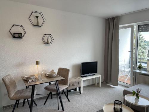 a living room with a table and a television at Ferienapartment Zeit am See 