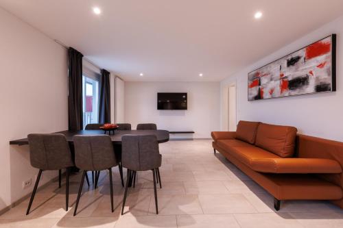a living room with a couch and a table and chairs at Hochwertige Wohnung zentral gelegen! in Winterthur