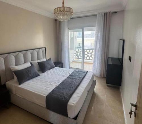 a bedroom with a large bed with a large window at Your privat peace place-Complexe Dream Hills in Tangier