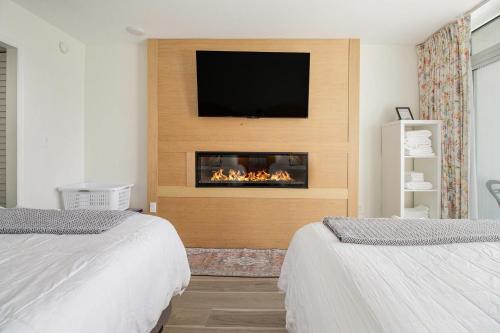 a room with a fireplace with a tv on a wall at Beachfront Bliss! Ocean Views, Lazy River, Pools, Hot Tubs, Near the Boardwalk in Myrtle Beach