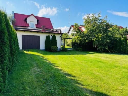 a house with a red roof and a green yard at Prywatny DOM z ogrodem w centrum CEKCYNA in Cekcyn